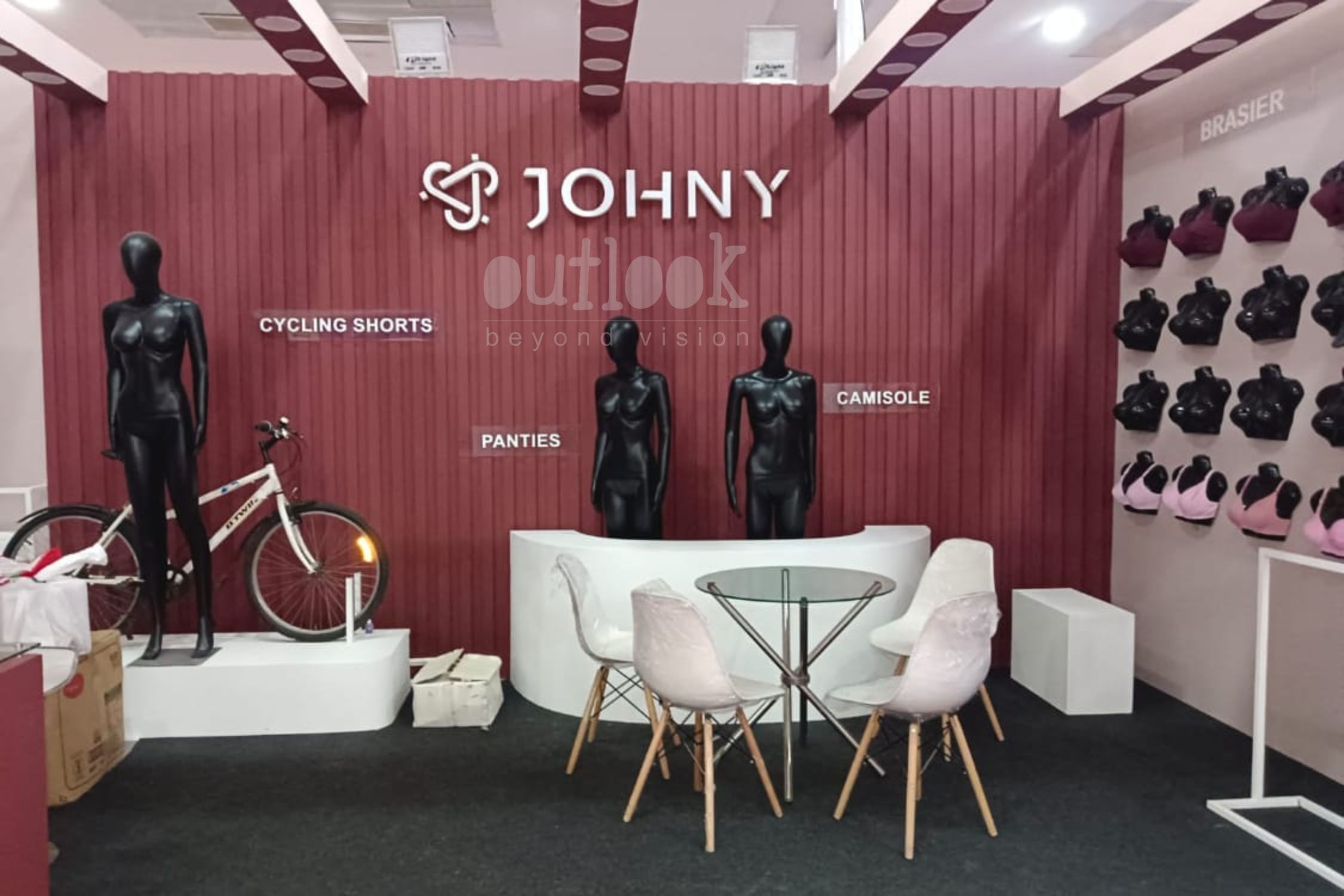 Stylish JOHNY exhibition booth with mannequins, cycling shorts, panties, camisoles, and lounge seating at trade show